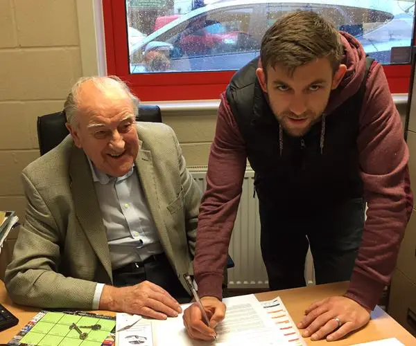 Below: Damian Reeves, with club secretary Derek Wilshaw, signs for another year and (above) in action last season