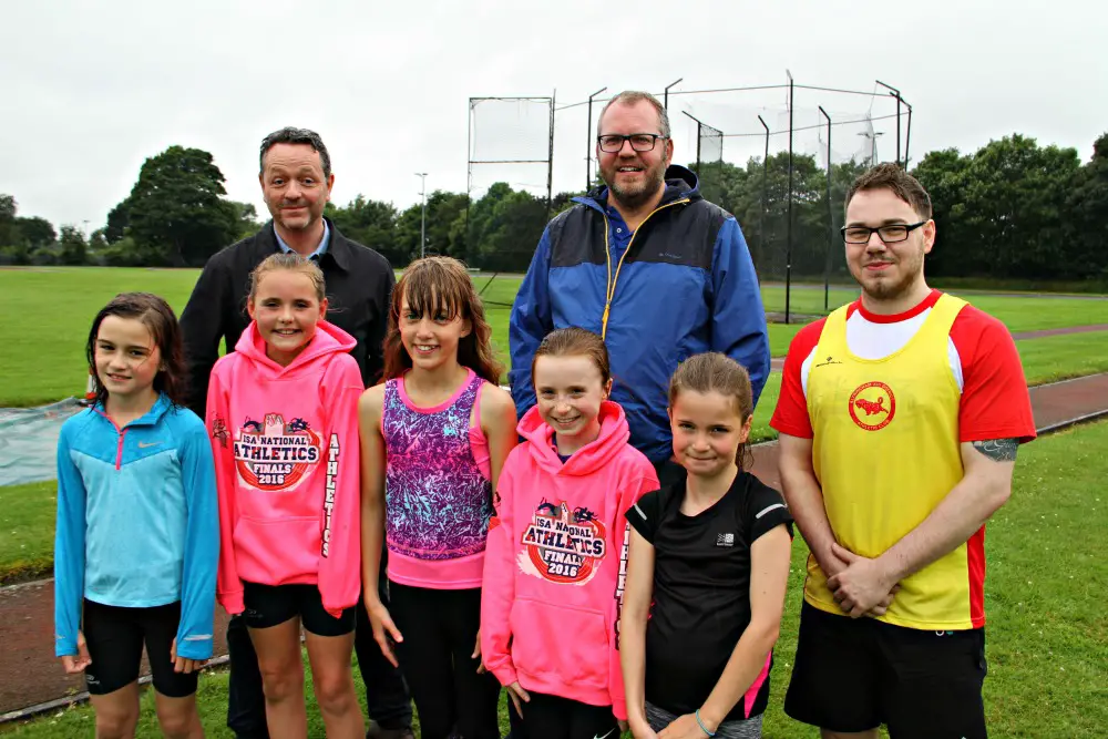 Sam (right) with The Sport Community's Dom McGuinness (left), Andrew McHale and five of the young athletes at Altrincham Athletics Club