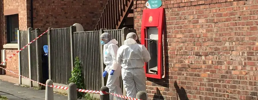 Forensic officers examine the scene hours after the raid on Timperley Post Office in June 2015