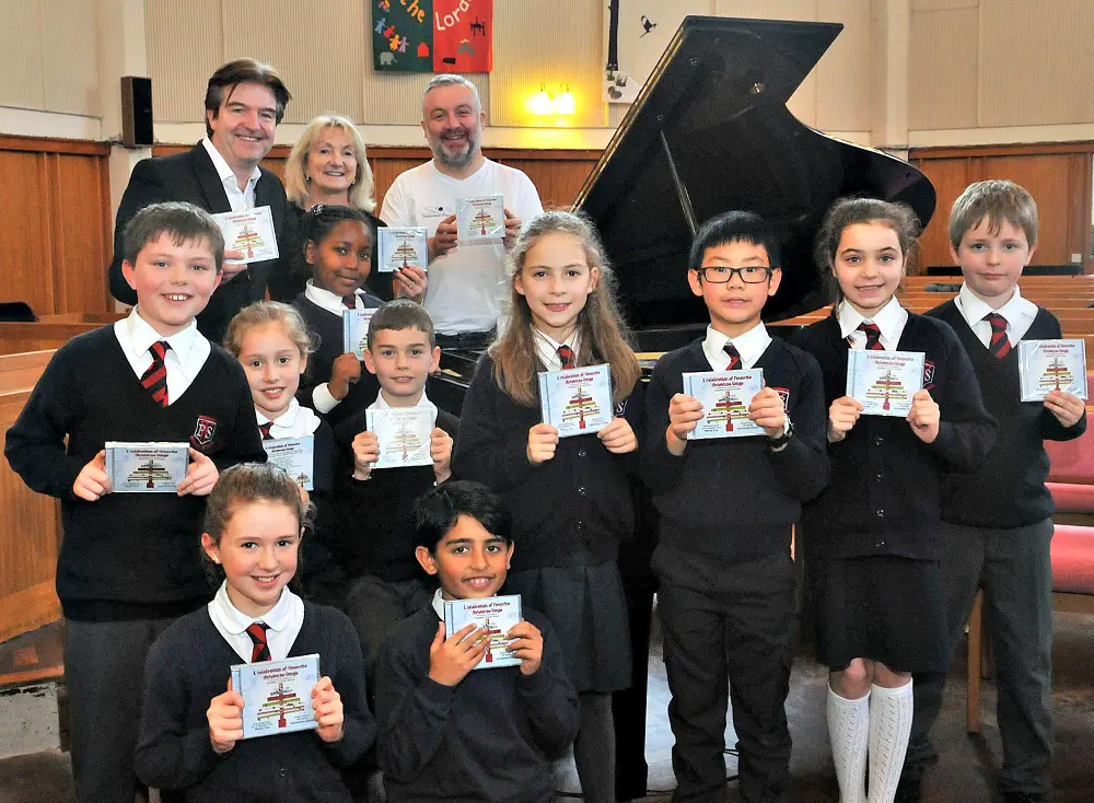 (top, l to r): Martin Toal, Woodheys Primary headteacher Laura Roberts and Destination Florida's Paul Bailey, with some of the choristers from St Hilda's