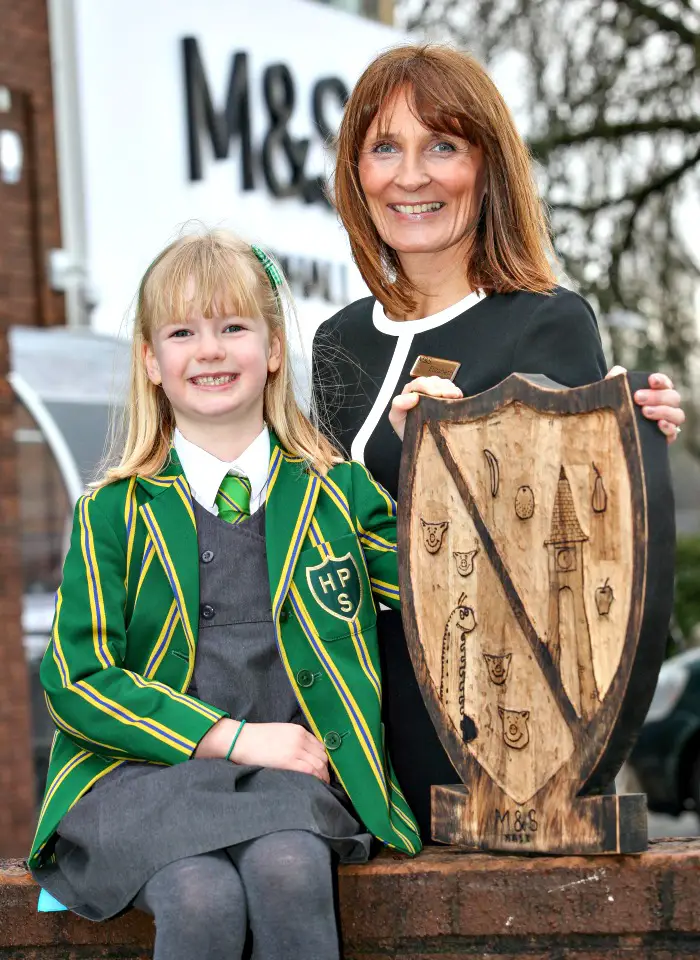 Hale Prep pupil Hannah Burns, 6, with her winning Coat of Arms design for the new M&S store  